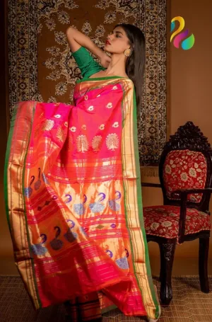 A woman draped in a vibrant pink and gold Paithani saree featuring intricate peacock motifs, posing elegantly with her hair down.