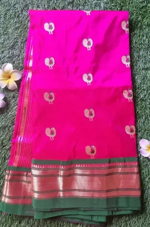 Bright pink tissue silk Paithani saree with peacock motifs and green borders, showcasing intricate gold detailing.