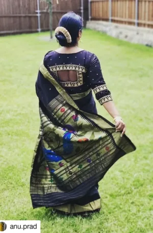 Woman wearing a black cotton Paithani saree with a peacock design, showcasing intricate embroidery and a traditional hairstyle.