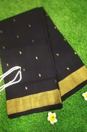 Black cotton Paithani saree with golden border and intricate patterns, displayed on a textured surface.