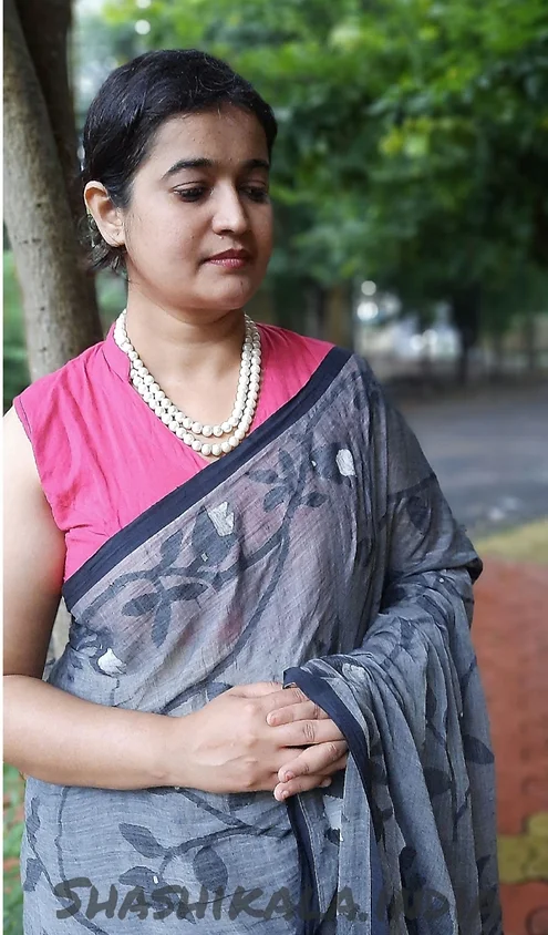 Handloom-Bengal-Cotton-Jamdani-1 Grey handloom Bengal cotton Jamdani saree with floral woven motifs, worn by woman in elegant traditional style