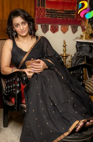 Black handloom Bengal cotton Jamdani saree with subtle gold butti motifs, worn by woman in elegant traditional style