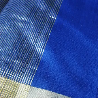 Blue Handloom Chanderi Silk Cotton Saree with Golden Zari Border Close view of a royal blue Chanderi handloom saree featuring a shiny golden zari striped border and smooth silk–cotton texture