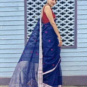 Rear side view of a navy blue Chanderi handloom cotton silk saree featuring small pink woven butta motifs and a subtle silver zari border with striped detailing, draped by a woman wearing a contrasting maroon blouse.