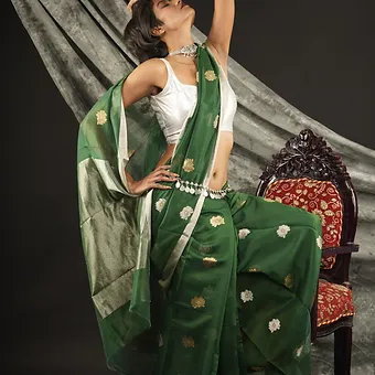 Handloom-Cotton-Silk-Chanderi-1 Woman wearing a green handloom cotton silk Chanderi saree with golden butti motifs and silver pallu, posing gracefully in a studio setting; elegant festive saree look.