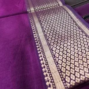 Purple handloom cotton silk Maheshwari saree with intricate silver zari border, shown in close-up; elegant traditional Maheshwari saree fabric design.