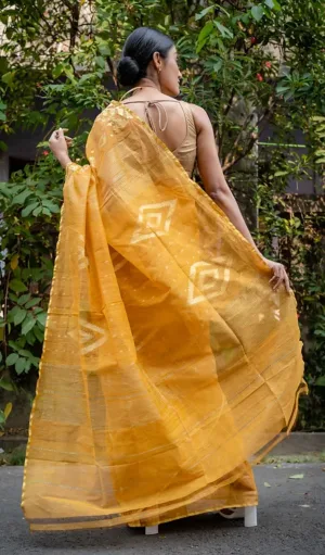 Mustard yellow handloom Dhakai Jamdani saree with geometric woven motifs, sheer cotton fabric worn by woman
