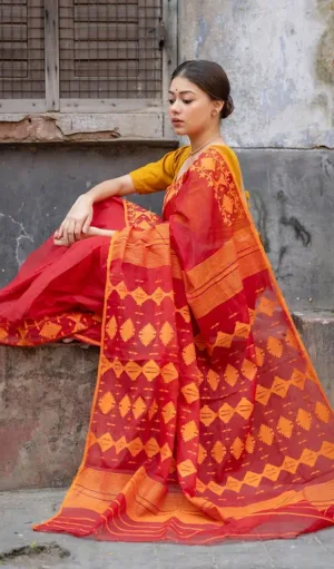 Red and mustard handloom Dhakai Jamdani saree with geometric floral motifs and traditional woven pallu, worn by woman