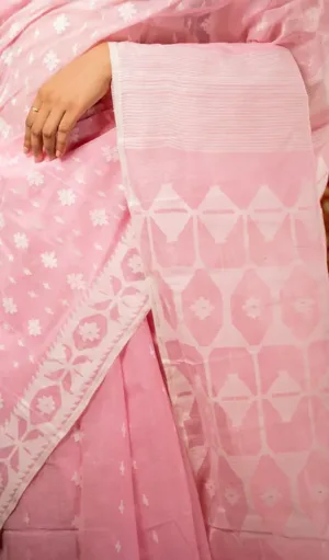 Light pink handloom Dhakai Jamdani saree with white floral motifs and geometric woven border, worn by woman