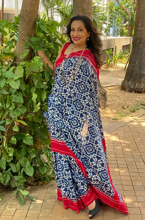 Handloom-Double-Ikat-Cotton-Saree-2 Woman wearing blue handloom double ikat cotton saree with white geometric patterns and red border
