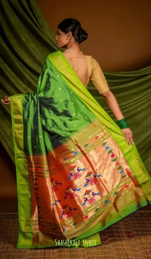 Woman draped in a handloom fusion Chanderi Paithani saree featuring vibrant green and orange colors with intricate patterns.
