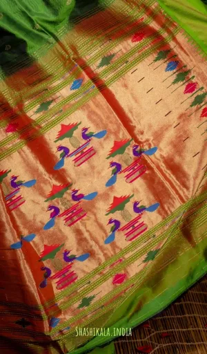 Chanderi Paithani handloom fabric featuring intricate floral and peacock motifs in vibrant colors on a golden background.