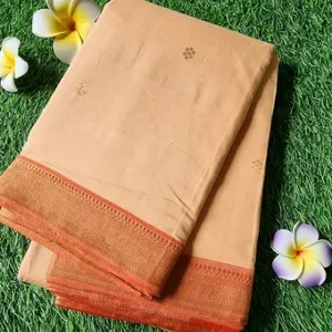 Handloom Mangalagiri saree in a light peach color with a nizam border, featuring intricate patterns and a smooth texture.