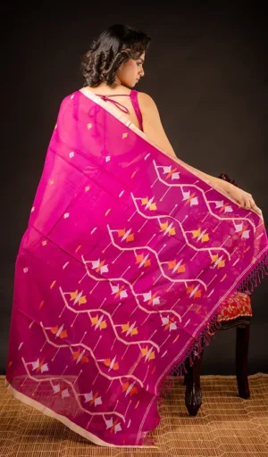Pink Jamdani saree with intricate floral patterns draped elegantly on a model, showcasing its lightweight fabric and detailed design.