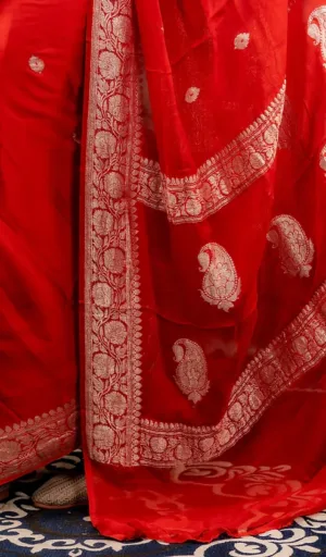 Red handloom pure chiffon Banarasi saree with intricate silver embroidery and paisley designs along the border.