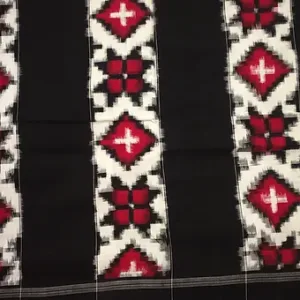 Close view of a Teliya Rumal handloom pure cotton saree featuring traditional Double Ikat weaving in black, white and red geometric patterns arranged in vertical stripes.