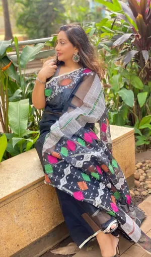 Black handloom pure cotton Jamdani saree with multicolour woven motifs and sheer pallu, worn by woman in elegant traditional style