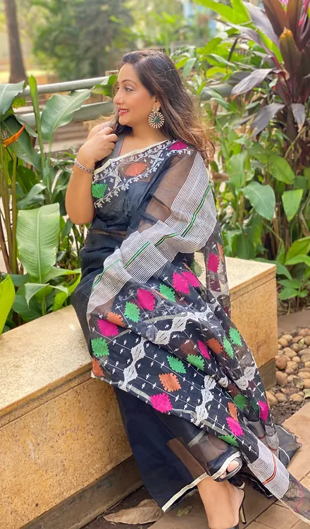 Handloom-Pure-Cotton-Jamdani-1 Black handloom pure cotton Jamdani saree with multicolour woven motifs and sheer pallu, worn by woman in elegant traditional style