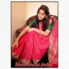 Woman draped in a red Lakshadeepam handloom cotton saree featuring subtle traditional check motifs and a rich golden zari border, paired with a contrasting green blouse