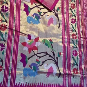 Handloom pure cotton Paithani saree with intricate floral and bird motifs in vibrant colors on a golden background.
