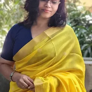 Woman wearing a yellow handloom pure silk Chanderi saree with intricate designs, complemented by a blue blouse.