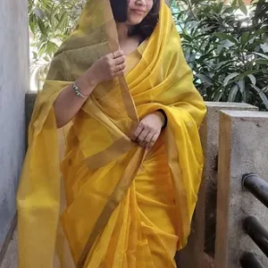 Woman wearing a yellow handloom pure silk Chanderi saree with a matching dupatta, posed elegantly outdoors.