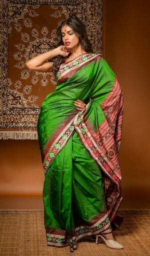 Woman wearing green handloom pure silk Odisha Ikat saree with red traditional woven border