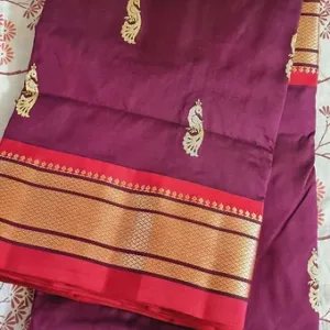 Handloom pure silk Paithani saree in deep purple with intricate peacock motifs and a contrasting red and gold border.
