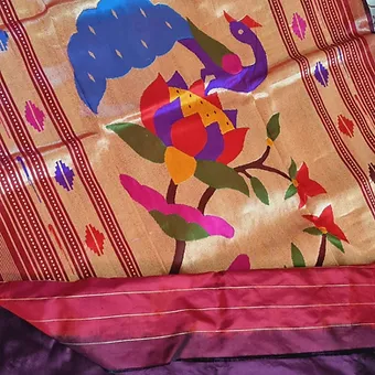 Handloom-Pure-Silk-Paithani-3 Handloom pure silk Paithani fabric featuring a colorful peacock and floral design on a gold background with a maroon border.