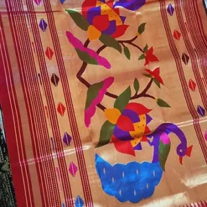Handloom pure silk Paithani fabric featuring vibrant floral and bird motifs in a colorful design.