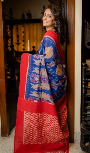 Woman wearing blue and red handloom single ikat cotton saree with traditional woven motifs