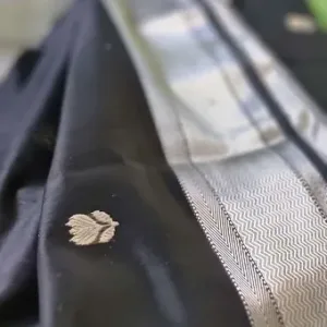 Handloom cotton silk Maheshwari saree in deep black with a silver zari border, featuring small traditional buti motifs woven across the body