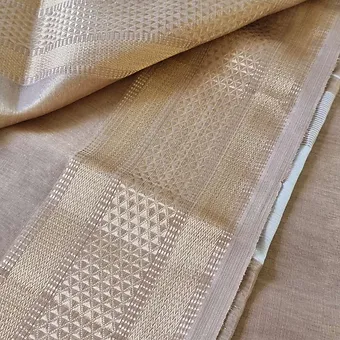 Handloom-cotton-silk-maheshwari-1 Handloom cotton silk Maheshwari saree in soft beige and champagne gold tones, featuring an intricately woven geometric zari border and smooth cotton-silk texture