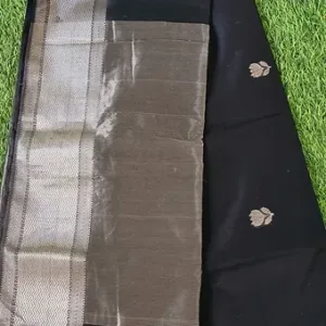 Handloom cotton silk Maheshwari saree featuring an olive grey body with a contrasting black pallu, accented by silver zari border and small traditional woven motifs
