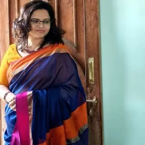 Model wearing a handloom cotton silk Maheshwari saree in royal blue with an orange and pink resham border, styled in a classic traditional drape