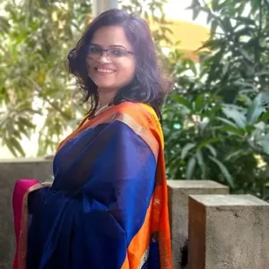Model wearing a handloom cotton silk Maheshwari saree in royal blue with an orange resham border, styled in a graceful traditional drape