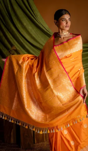 Orange handloom Katan silk Banarasi saree with rich gold zari floral weaving, traditional pallu and tassel border