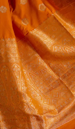 Orange handloom Katan silk Banarasi saree featuring intricate gold zari floral motifs and richly woven traditional pallu