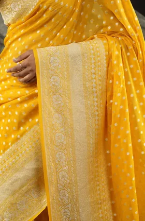 Yellow handloom khadi georgette saree with intricate Banarasi patterns and polka dot design, draped elegantly.