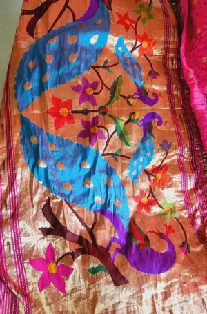 Handloom Paithani saree with vibrant peacock and floral motifs in shades of blue, orange, and pink, showcasing intricate embroidery.