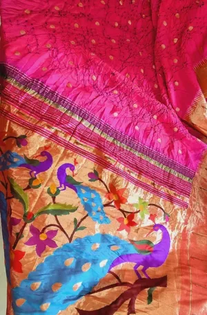 Handloom Paithani saree with vibrant pink and orange colors, featuring intricate peacock and floral designs along the border.