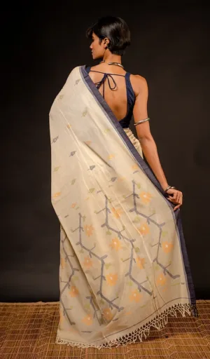 Woman wearing off-white handloom pure cotton Jamdani saree with multicolour woven motifs and blue border