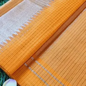 Mustard handloom pure cotton Mangalagiri saree with fine striped weave and subtle silver zari border, neatly folded on grass; lightweight traditional cotton saree.