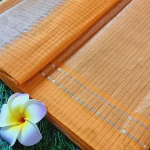 Mustard handloom pure cotton Mangalagiri saree with fine striped weave and subtle zari border, displayed flat with flower accent; lightweight traditional cotton saree.