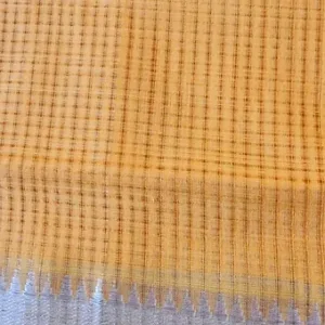 Close-up of mustard handloom pure cotton Mangalagiri saree with fine checked weave and subtle silver zari border, showcasing lightweight traditional cotton fabric.