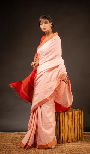Peach handloom pure cotton Mangalagiri saree with red and gold Nizam border, worn by woman in elegant traditional style