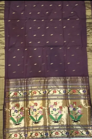 Handloom pure cotton Paithani saree with a purple body and intricate floral patterns in gold and colorful threads along the border.