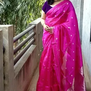 A woman wearing a bright pink Chanderi silk saree adorned with small decorative motifs, paired with a purple blouse.