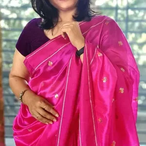 Woman wearing a bright pink handloom silk Chanderi saree with floral motifs and a contrasting blouse.