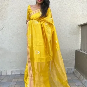 Model wearing a bright yellow pure silk Chanderi saree featuring delicate white floral butta embroidery, a soft beige zari border with striped detail and a glossy traditional pallu